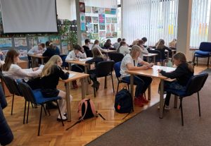 uczniowie piszący test konkursowy w bibliotece w ramach konkursu "Z książką na ty"
