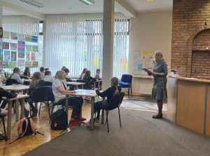 uczniowie piszący test konkursowy w bibliotece w ramach konkursu "Z książką na ty"