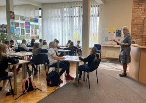 uczniowie piszący test konkursowy w bibliotece w ramach konkursu "Z książką na ty"