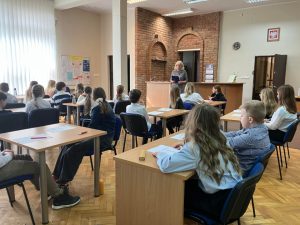 uczniowie piszący test konkursowy w bibliotece w ramach konkursu "Z książką na ty"